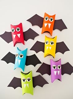 paper bats with eyes and fangs on them are arranged in the shape of bat's