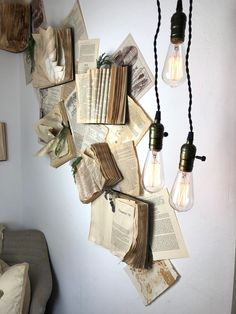 an arrangement of books and light bulbs hanging from the wall