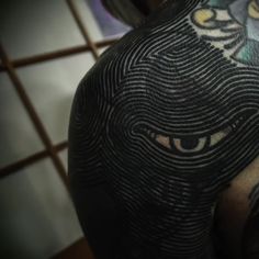 a close up of a person's head with tattoos on his arm and shoulder