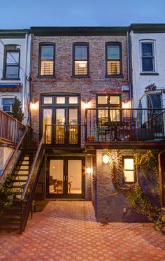 an apartment building with stairs leading up to the second floor and two story windows on each side