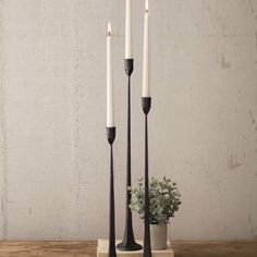 three candles are sitting on top of a wooden table