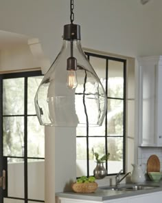 a glass light hanging from the ceiling in a kitchen