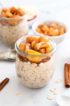 two jars filled with oatmeal and cinnamons on a table next to spoons