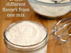 there is a small glass jar filled with flour next to a whisk on the table