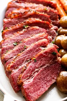 corned beef, potatoes and carrots on a white platter with parsley