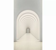 an empty hallway with white walls and arches leading into the light at the end of the tunnel