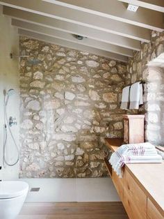 a bathroom with stone walls and wood flooring