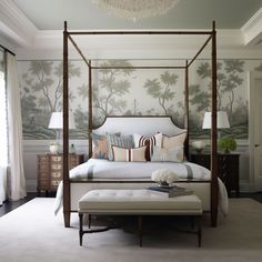 a bedroom with a canopy bed and wallpaper on the walls, along with a footstool