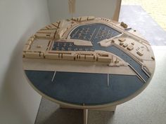 a wooden model of a city on display