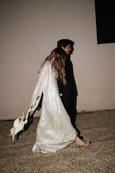 the bride and groom are walking down the street