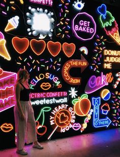 a woman standing in front of a neon sign