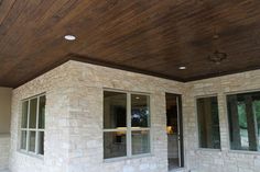 an outside view of a house with two windows and a ceiling fan in the corner