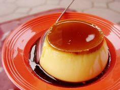 a dessert is sitting on an orange plate with a spoon sticking out of the top