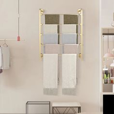 two towels hanging on the wall in a bathroom next to a table with chairs and other items