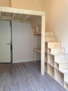 an empty room with stairs and shelves in it