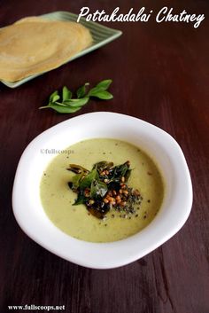 a white bowl filled with soup on top of a wooden table