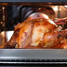 a roasted chicken in an oven with the door open