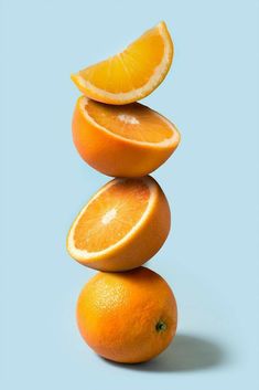 three oranges stacked on top of each other in the shape of a pyramid with one slice cut out