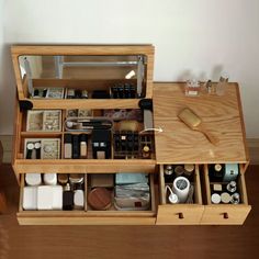 an open wooden drawer with various items in it