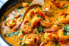 a close up of a bowl of soup with shrimp and garnish on top