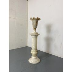 a white vase sitting on top of a pedestal