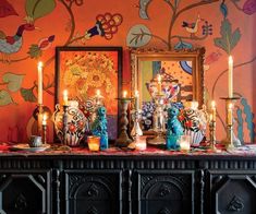 an ornate table with candles and pictures on it