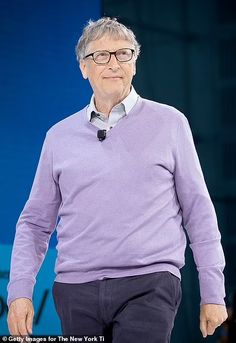 an older man wearing glasses and a purple sweater is walking down the runway with his hands in his pockets