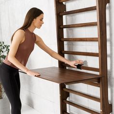 a woman standing next to a wooden shelf