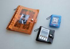 three different types of electronic gadgets are on the table next to an orange case