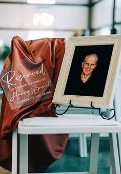 an old man's portrait is on display next to a red satin bag that says reserved