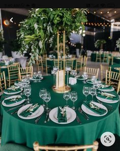 the table is set with green linens and place settings