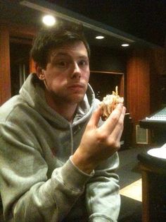 a man sitting at a table eating a sandwich