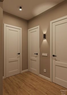 an empty room with three white doors and one light on the wall in front of it