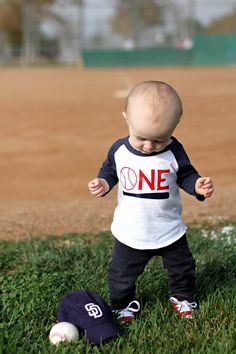 a baby standing on top of a baseball field