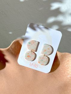 a close up of a person's hand holding a pair of earrings