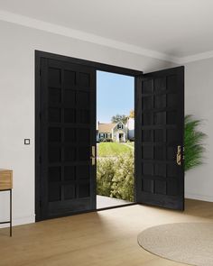 an empty room with two doors open and a potted plant on the floor next to it