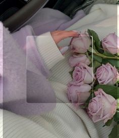 a person in a car with pink roses