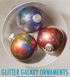 three shiny ornaments in a bowl on a table