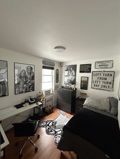 a bedroom with pictures on the wall and a bed in front of a desk area