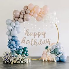 a birthday arch with balloons and flowers