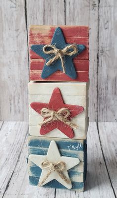 three wooden stars are stacked on top of each other, one is red white and blue