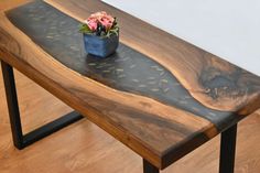 a wooden table with metal legs and a flower pot on it's end shelf