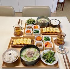 a table topped with plates and bowls filled with different types of food next to chopsticks