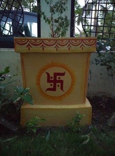 a yellow and red planter sitting on top of a lush green field