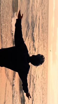 a person standing in the snow with their arms up