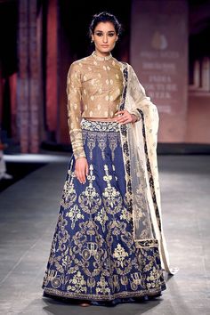 This lehenga is embroidered in zari and dabka in raw silk lehenga along with a golden blouse. Blouse is also has hand-embellished detailing on neck and sleeves. Long Choli Blouse Design, Indigo Lehenga, Homemade Bars, Choli Blouse Design, Golden Blouse, Lehenga Pattern, Raw Silk Lehenga, Indian Lehenga Choli