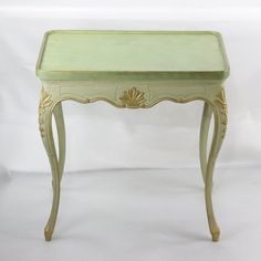 a small green table with a drawer on it