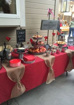 a red table topped with lots of food and desserts on top of it's sides