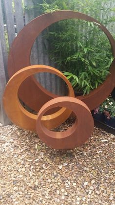 a group of wooden circles sitting next to each other on top of a gravel ground