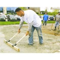 a man is shoveling dirt in front of other men working on the ground with tools